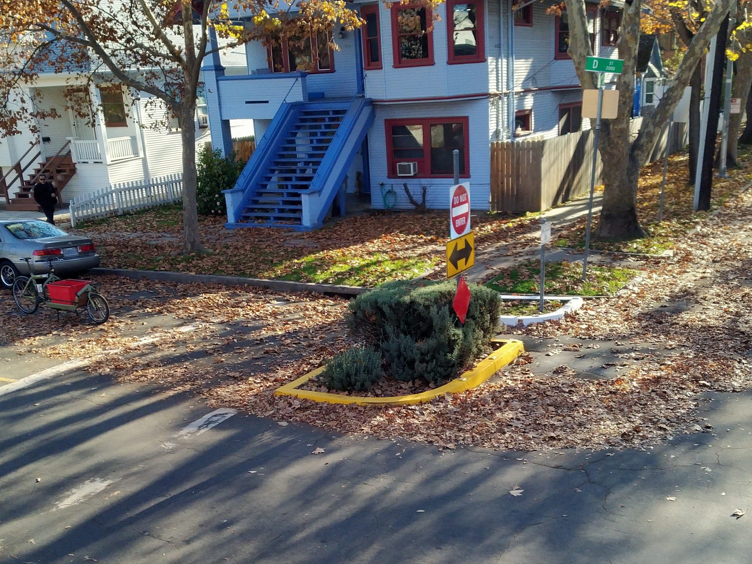 Street with a barrier preventing through traffic on one side. 