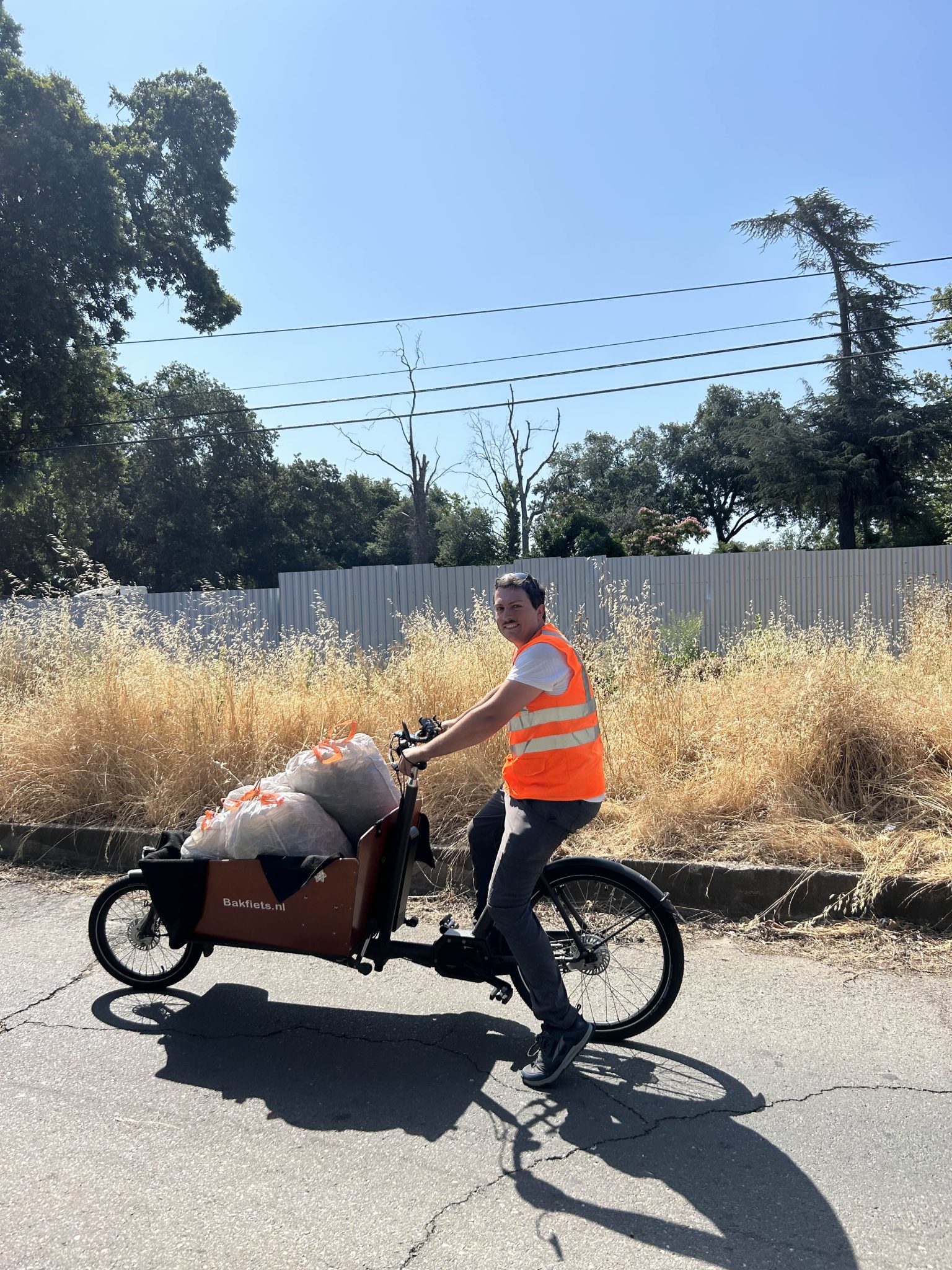 Riding a cargo bike on a clean bike lane, filled with cleared trash and debris.