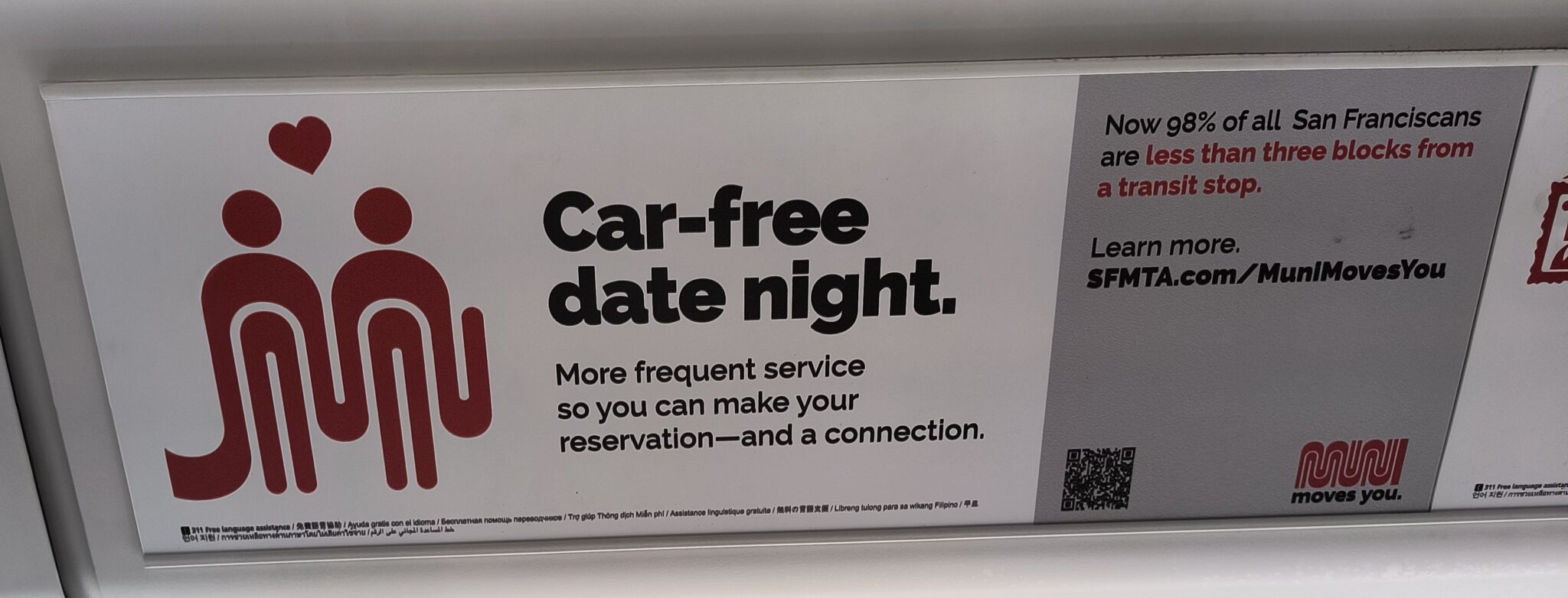 Ad on train with Muni logo stylized as two people holding hands with a heart between them. Text reads: Car-free date night.